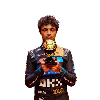 Lando Norris 2026 McLaren 1000th Monaco GP F1 race suit featuring a black, papaya orange and blue colourway with special edition McLaren detailing