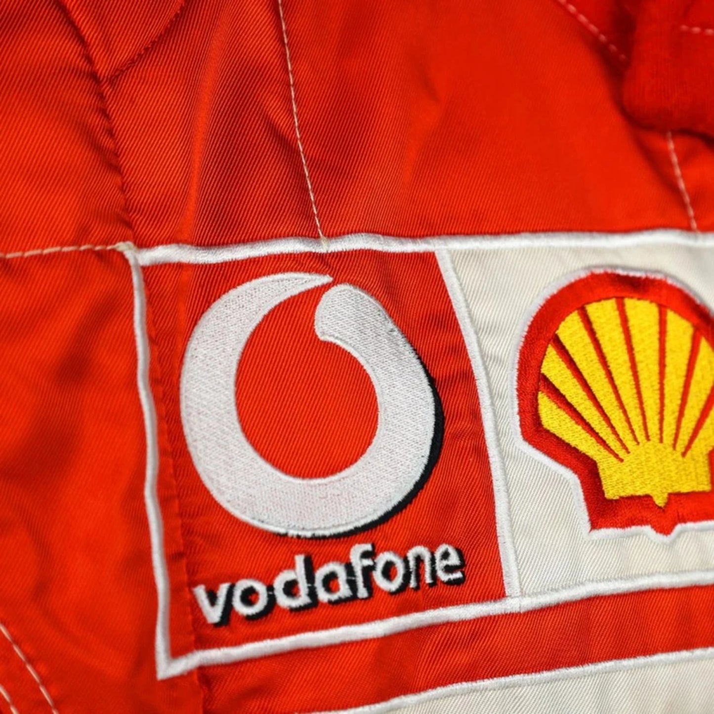 Michael Schumacher 2006 Ferrari F1 Racing Suit in red and white featuring iconic Ferrari racing graphics, authentic sponsor detailing, and championship inspired design