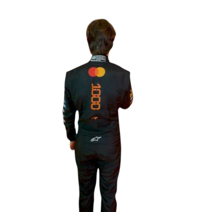 Oscar Piastri 2026 McLaren 1000th Monaco GP F1 race suit featuring a black, papaya orange and blue colourway with special edition McLaren detailing
